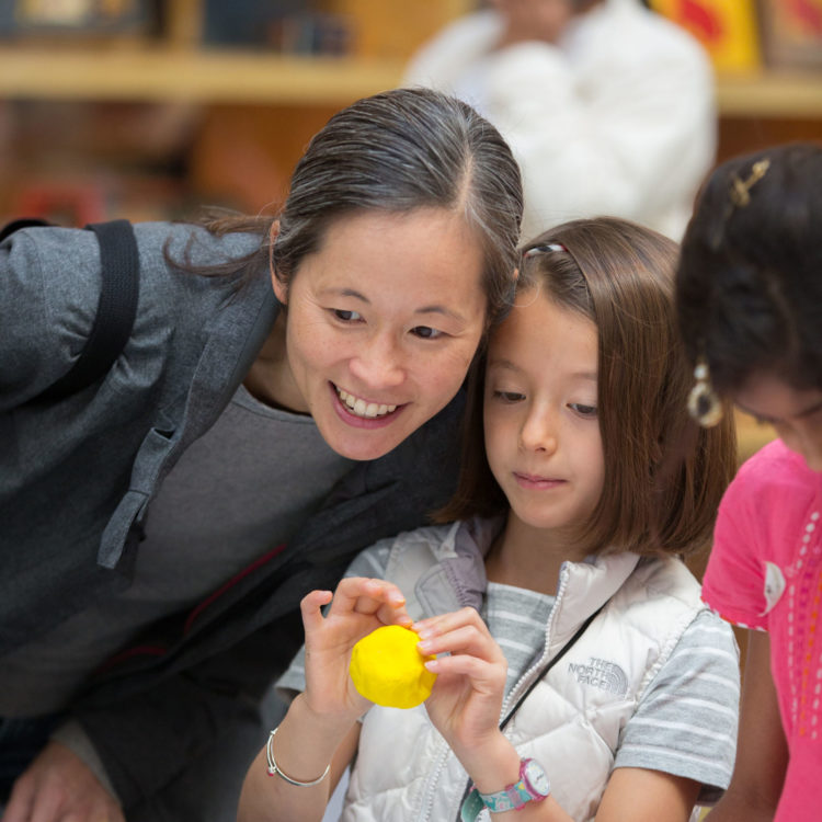 A woman and a child doing crafts at the museum.