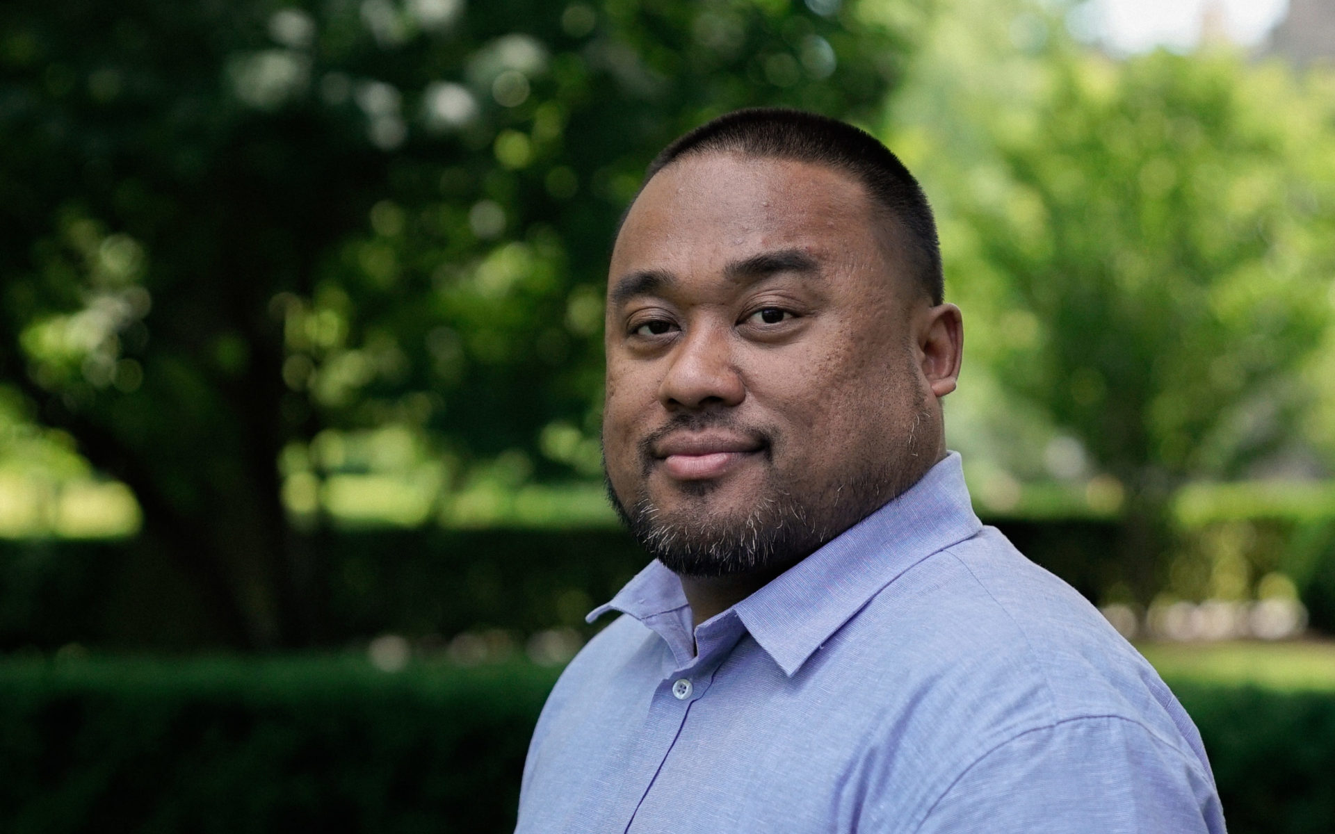 Headshot of a man in a blue shirt.