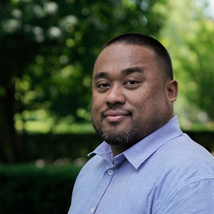 Headshot of a man in a blue shirt.