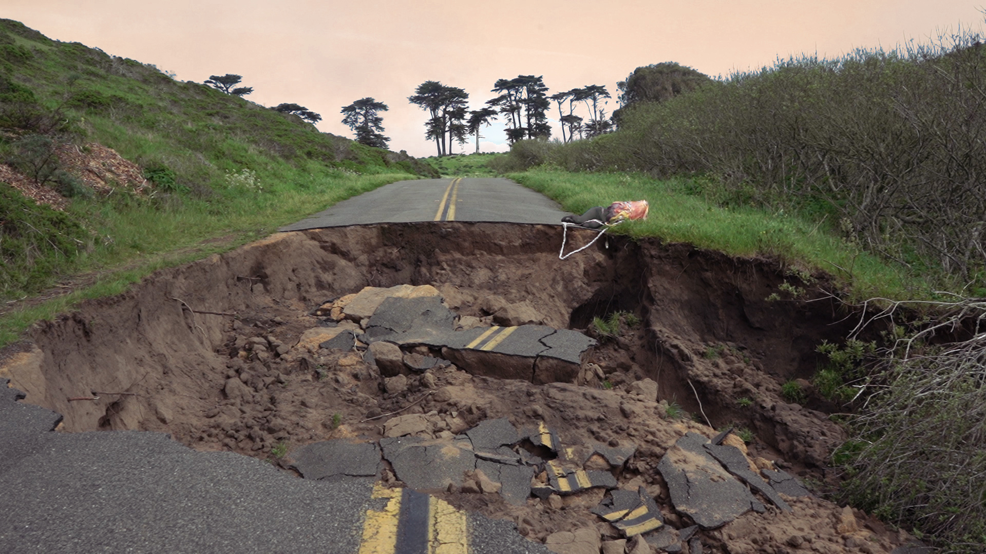 A road with a large section wiped out in the middle.