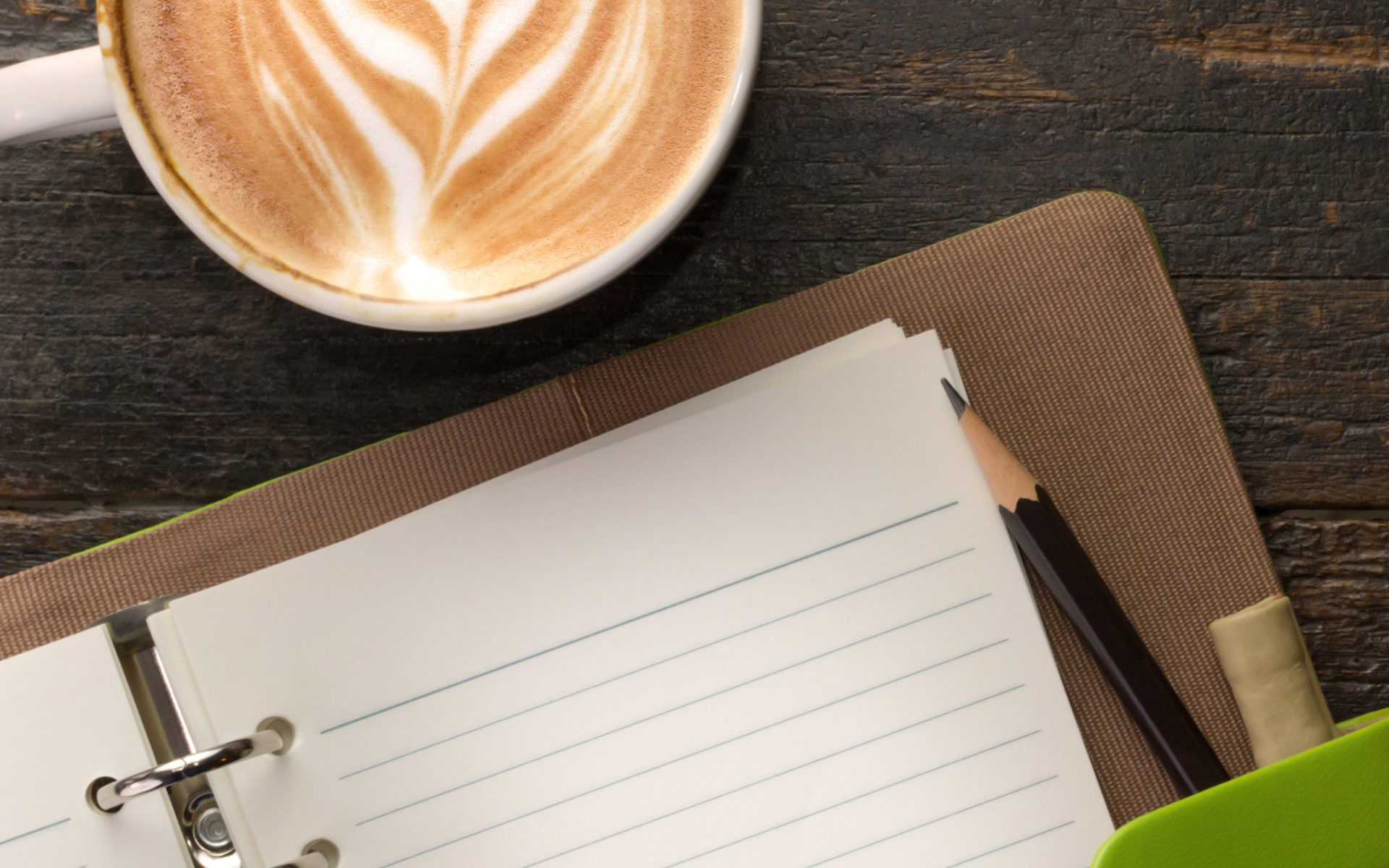 Open blank notebook beside a cup of coffee.