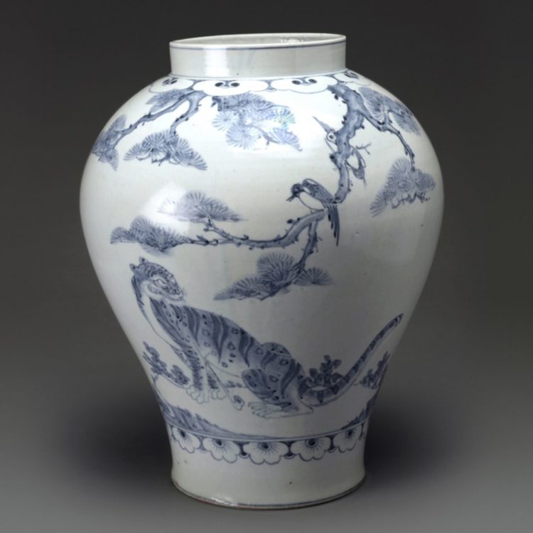 A wide-mouthed white porcelain jar with a tiger and magpie painted in blue.