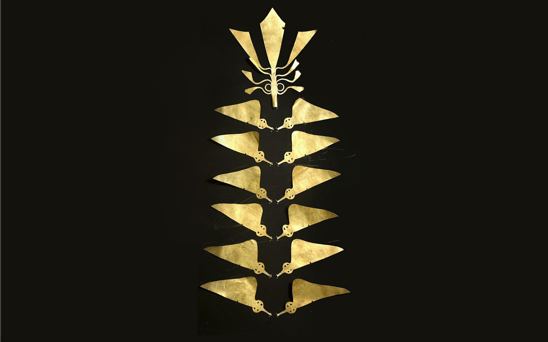 Gold headdress comprised of several flat triangular pieces.