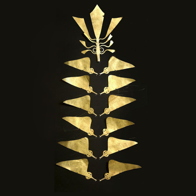 Gold headdress comprised of several flat triangular pieces.