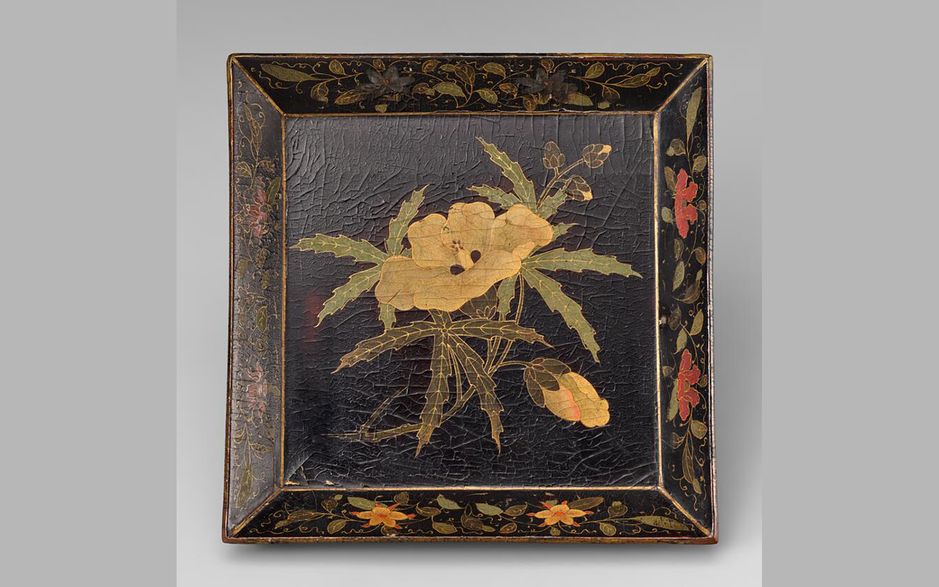 Square tray in black lacquer with painted design of yellow and red flowers.