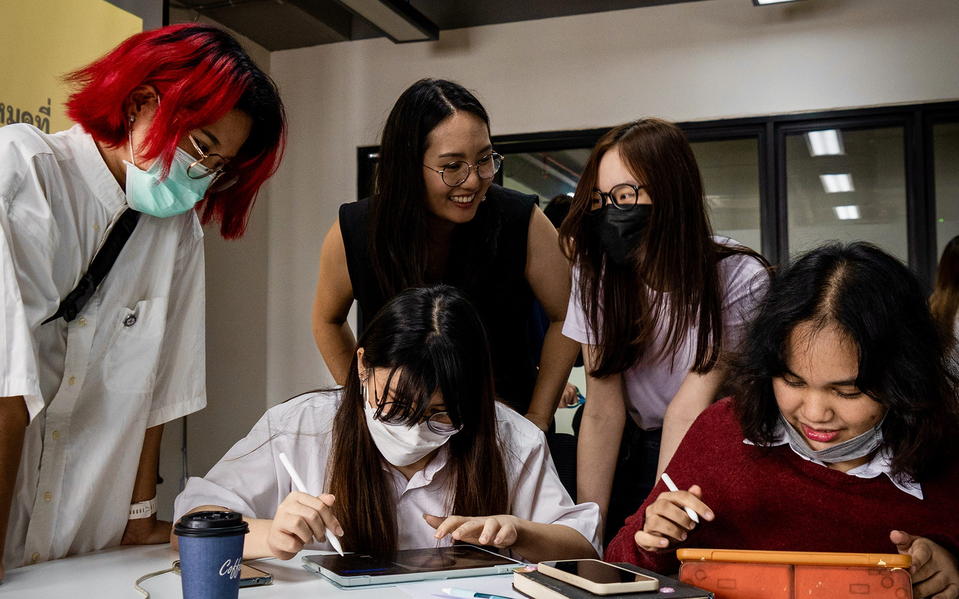 Five people talking and working around a table.