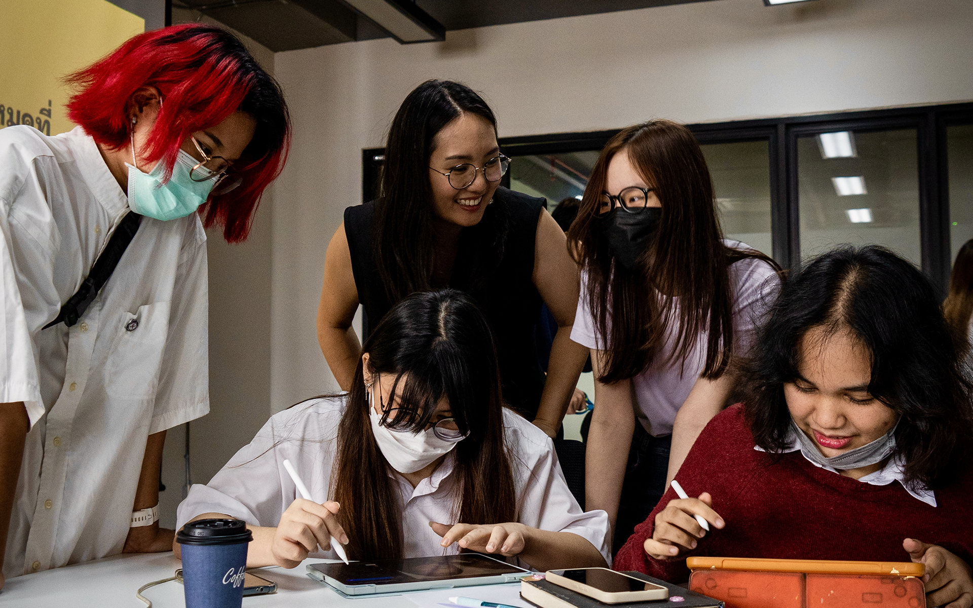 Five people talking and working around a table.