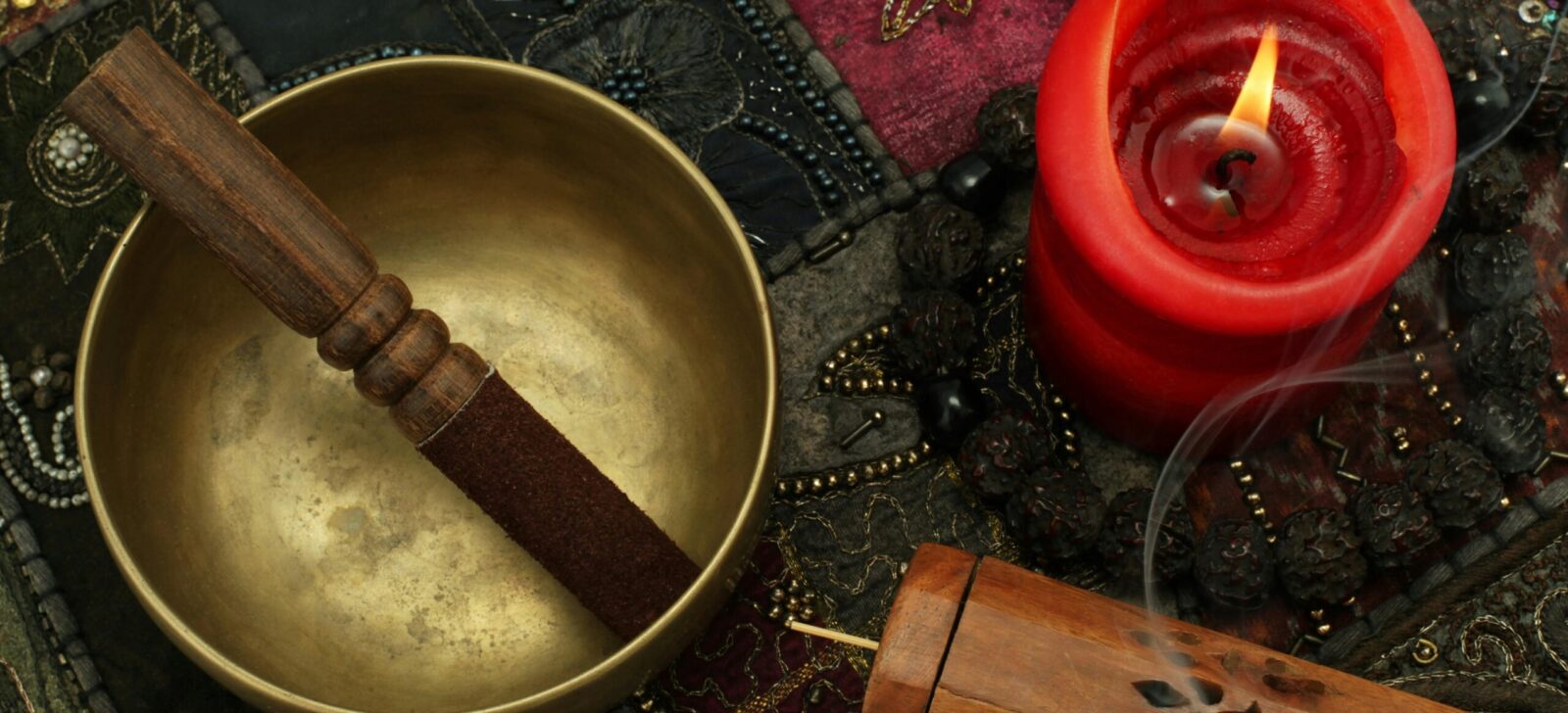 A photographic collage of a singing bowl, candle and textiles used in sound healing.